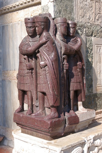 Venedig, Südostecke von San Marco, sog. Tetrarchengruppe (aus Porphyr): Die vier Herrscher tragen einen pileus pannonicus auf dem Kopf und sind mit einem *Paludamentum bekleidet (um 300).