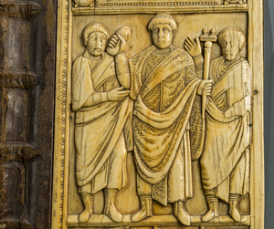 Halberstadt, Domschatz, Elfenbeinrelief: Deutlich ist beim Konsul und seinen beiden Begleitern die mehrfache Umwicklung des Beines mit den Riemen von calcei zu erkennen (frühes 5. Jh.).